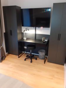 a black desk with a monitor and a chair at 100pro-Apartments in Detmold
