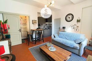 a living room with a couch and a table at Le Cloître Arles Centre in Arles
