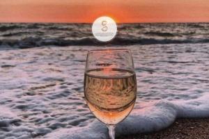 a glass of wine sitting on the beach at Le Cloître Arles Centre in Arles