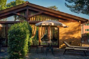 an umbrella and chairs in front of a house at Borgo San Benedetto in Montaione