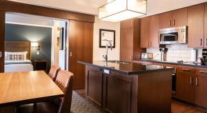 eine Küche mit einem Tisch und ein Zimmer mit einem Bett in der Unterkunft Evolution Whistler, by Lodging Ovations in Whistler