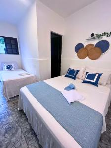 a bedroom with two beds with blue and white at Nalu Suítes Maresias in Maresias