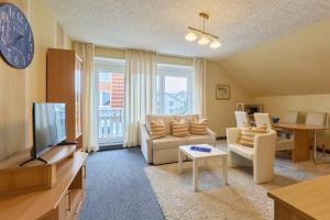 a living room with a couch and a tv at arador CITY Hotel in Bad Oeynhausen
