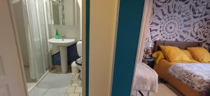 a bedroom with a bed and a sink and a mirror at Ideal pour une pause in Saint-Georges-sur-Cher +14 photos