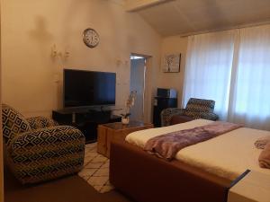 a bedroom with a bed and a flat screen tv at Portia inn accommodation in Pretoria
