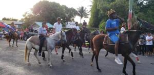 eine Gruppe von Menschen, die auf Pferden auf einer Straße reiten in der Unterkunft Maxroomz in San Ignacio