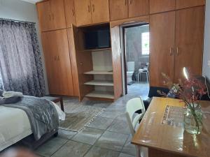 a bedroom with a bed and a table and a tv at Altenburgh Accommodation - Apartments in Somerset East