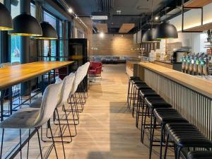 ein Restaurant mit einer langen Bar und weißen Stühlen in der Unterkunft Campingresort Hinterstoder in Hinterstoder