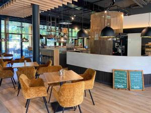 ein Restaurant mit Tischen, Stühlen und einer Theke in der Unterkunft Campingresort Hinterstoder in Hinterstoder