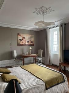 a bedroom with a bed and a table with chairs at La Chambre d'Adèle in Louhans