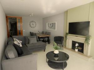 a living room with a couch and a table and a television at Harmony Seafront 365 by Can Ventet in Port de Pollensa