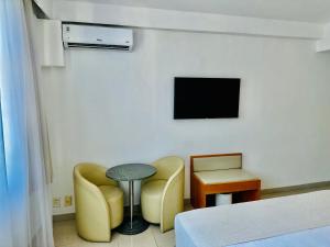 a room with two chairs and a table and a tv at Copacabana Mar Hotel in Rio de Janeiro