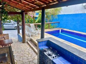 a swimming pool with a stove in a blue tiled at Nalu Suítes Maresias in Maresias