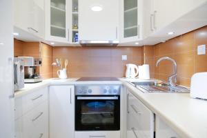 cocina con armarios blancos y horno en Guest Apartment Visoko, en Visoko