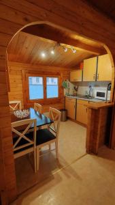 a kitchen with a table and chairs in a cabin at Holzhaus direkt am See in Priepert