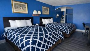 two beds in a hotel room with blue walls at Apollo Lodge and RV Park in Fairfield