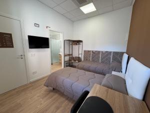 a room with two beds and a flat screen tv at Elco Rooms Malpensa in Lonate Pozzolo