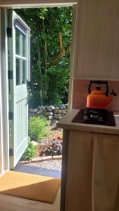 a pot on a stove next to a door at Cwt Cen y Coed in Llanferres