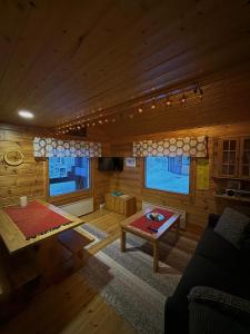 a living room with a table and a couch in a cabin at Pusikko - Cozy Lake Villa - Ice Swimming - Sauna - Fireplace - Barbeque Shed in Kuusamo