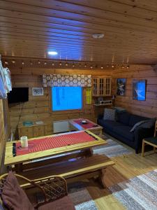 a living room with a couch and a table at Pusikko - Cozy Lake Villa - Ice Swimming - Sauna - Fireplace - Barbeque Shed in Kuusamo