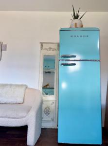 a blue refrigerator in a room with a couch at Morse Cottage in Houston