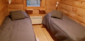 a bedroom with two beds in a tiny house at Pusikko - Cozy Lake Villa - Ice Swimming - Sauna - Fireplace - Barbeque Shed in Kuusamo +15 photos