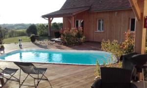 a swimming pool on a wooden deck next to a house at Les jumelles in Sarlat-la-Canéda