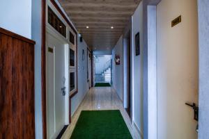 an empty hallway with a green rug in a room at Hotel O Kanchan Residency in Kota