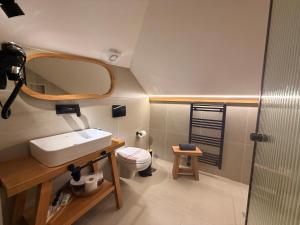a bathroom with a sink and a toilet and a mirror at The Stone Sky Hotel in Gjirokastër