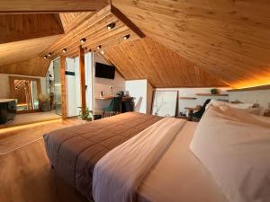 a large bed in a room with wooden ceilings at The Stone Sky Hotel in Gjirokastër