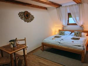 a bedroom with a bed and a table and a window at Althanský penzion in Znojmo