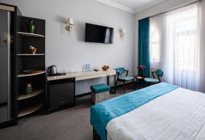a bedroom with a bed and a desk and a tv at KHIVA RESIDENCE - Eastern Hotel in Khiva