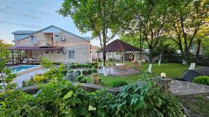 a garden with a house and a swimming pool at Family Hotel Lago & Wine Cellar in Lagodekhi