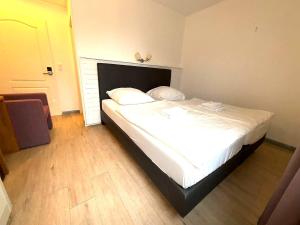 ein Schlafzimmer mit einem Bett mit weißen Laken und Kissen in der Unterkunft M2 Rooms in Lübeck + 2 Fotos