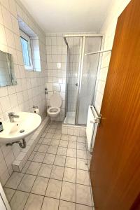 ein Badezimmer mit Toilette, Waschbecken und Dusche in der Unterkunft M2 Rooms in Lübeck