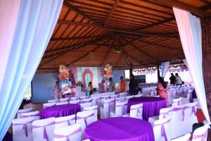 a banquet hall with purple tables and white chairs at Unwind Farm Retreat in Hyderabad