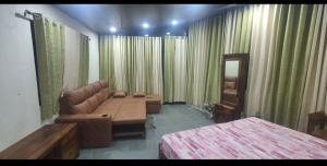 a room with a bed and a couch and a mirror at Unwind Farm Retreat in Hyderabad