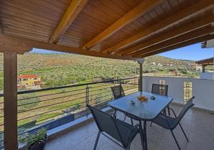 a table and chairs on a balcony with a view at Spacious 3bd Apartment in Lefkakia, Nafplio in Levkákia