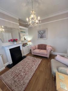 a living room with a couch and a fireplace at The Lily Pad - Boutique Townhouse, a short walk to Town Center and Racecourse in Cheltenham +35 photos