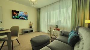a living room with a couch and a table at Elegante Apartments & Jacuzzi Władysławowo - Adults Only in Władysławowo