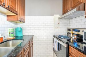 a kitchen with a sink and a stove at Charming Newly Renovated Condo - Glenview West in Hamilton +6 photos