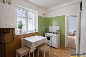 a kitchen with green walls and a stove and a table at Emese Central Square Vintage Apartment in Târgu-Mureş