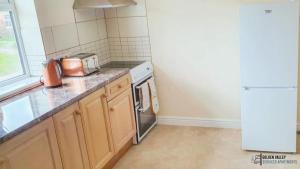 a small kitchen with a stove and a microwave at White Jasmine in Stroud in Gloucestershire