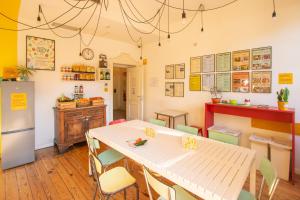a dining room with a table and a refrigerator at Ostello Bello Lake Como in Como