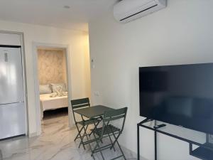 a living room with a table and chairs and a bedroom at Marco Apartment By Torremolinos On-line in Torremolinos