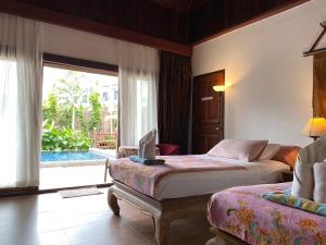 a bedroom with two beds and a view of a pool at Sea Pines & Liberg in Nai Yang Beach +118 photos