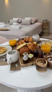 a table with a tray of bread and orange juice at Les Dômes du Moulin in Urtaca