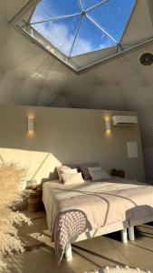 a bedroom with a large bed with a large window at Les Dômes du Moulin in Urtaca