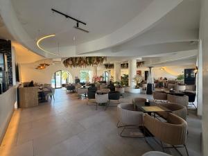 a restaurant with tables and chairs in a room at Yocca Hotel Residence in Hammamet
