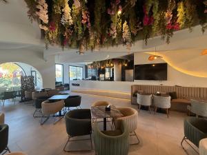 a restaurant with tables and chairs and flowers hanging from the ceiling at Yocca Hotel Residence in Hammamet +21 photos